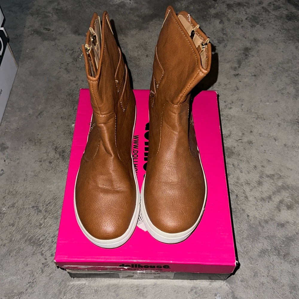 Tan colored boots with gold belts on the sides
